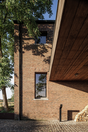 Bakstenen villa met houten luifel en een Sotto Terra laadpunt aan de oprit