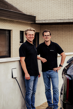 Twee mannen in zwarte Sotto-polo's naast een Sotto Murra Solid laadpunt aan een witte muur